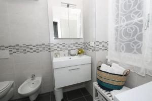 a bathroom with a sink and a toilet and a mirror at Apartment A lago private beach and parking in Oliveto Lario +48 photos