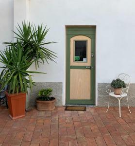 
a green door leading to a garden with a bench at Borgo dei Pescatori Lecco in Lecco
