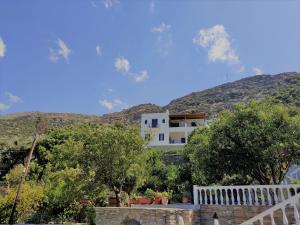 a white house with a mountain in the background at Palaiopoli View Studios in Palaiópolis