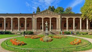 un gran edificio con un jardín delante de él en City Apartment an der Caracalla Therme, en Baden-Baden