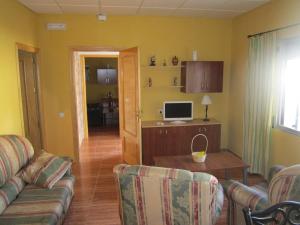 a living room with a couch and a desk with a computer at Apartamentos Venta Don Quijote in Almagro