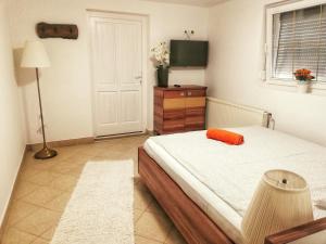 una camera da letto con un cuscino arancione di Tassi Halászcsárda-Harcsa ház a Tass