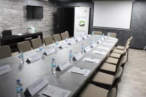 een vergaderruimte met een lange tafel met flessen water bij West Tower Hotel in Koetaisi