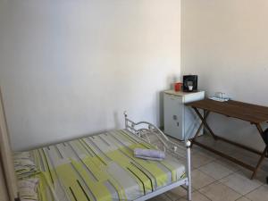um pequeno quarto com uma cama e uma mesa em Chambres les pieds dans l’eau résidence Cypria em Les Trois-Îlets