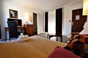 Habitación de hotel con cama y escritorio en Hotel Des Tuileries, en Nimes
