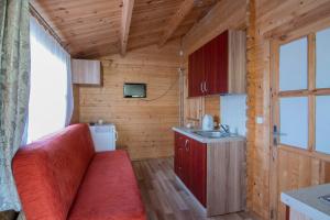 a small kitchen with a red couch in a room at Nameliai Gulbės takas in Šventoji +89 photos