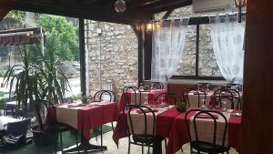 a dining room with tables and chairs with red table cloth at LA PETITE MAISON D'ARNAL in Sainte-Énimie