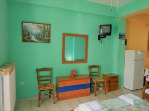 a room with a blue wall with chairs and a table and a mirror at Palaiopoli View Studios in Palaiópolis