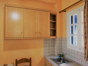 a kitchen with wooden cabinets and a sink at Palaiopoli View Studios in Palaiópolis +50 photos