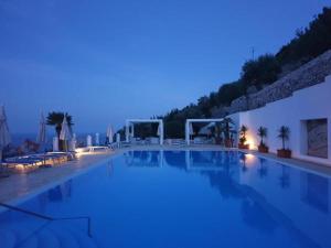 a swimming pool at night with the lights on at Residence Montelci in Mattinata