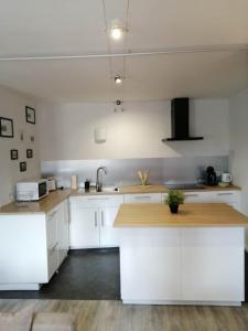 a kitchen with white cabinets and a wooden counter top at Le regard de Mona Lisa in Amboise