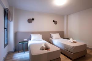 a room with two beds and a table at GroundFloor 2BR Apt with Smallyard near the heart of Kalamata in Kalamata