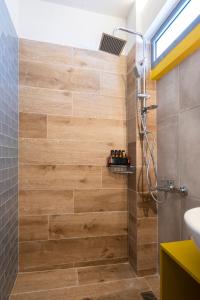 a bathroom with a shower with a wooden wall at GroundFloor 2BR Apt with Smallyard near the heart of Kalamata in Kalamata +20 photos