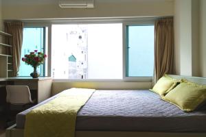 1 dormitorio con 1 cama y 2 ventanas grandes en Lotus House en Hanói