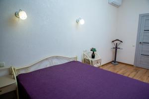 a bedroom with a purple bed with a purple blanket at Золотой Бугаз in Gribovka
