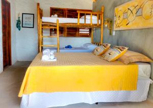 a bedroom with a yellow bed with two bunk beds at Flats Macapá Meu Amor in Luis Correia