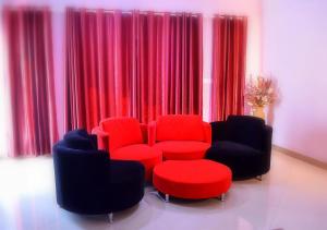 a living room with two chairs and a red chair at Niv Villa in Flic-en-Flac