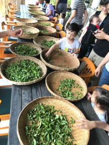 um grupo de cestos cheios de verduras numa mesa de madeira em Green Ozland B&B em Dongshan