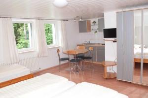 a room with a kitchen and a table and a bed at Waldgasthaus in Hochburg
