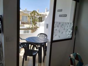 ein Tisch und Stühle auf einem Balkon mit Fenster in der Unterkunft Superbe appartement à Costa Antigua in Costa de Antigua