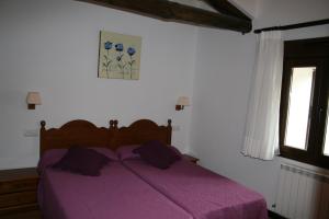 een paars bed in een slaapkamer met een raam bij Hotel Rural San Millán in Oncala