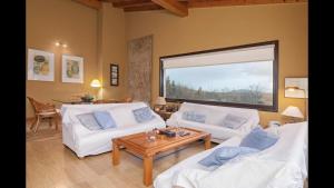 Una sala de estar con dos sofás blancos y una mesa. en El Mazo Meruelo, en San Miguel de Meruelo