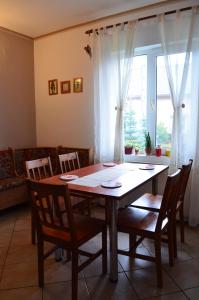 a dining room table with chairs and a large window at Casa Julia in Bran