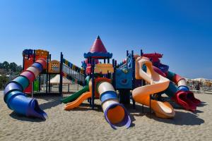 un parco giochi nella sabbia con un mucchio di scivoli di Hotel Etoile a Rimini
