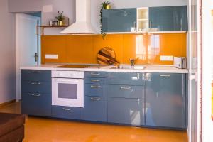 uma cozinha com armários azuis e um lavatório em Apartamento Coral em Denia