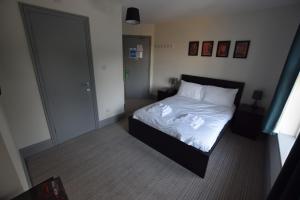 The Crow Inn في شيفيلد: غرفة نوم بسرير ذو شراشف بيضاء ومخدات بيضاء