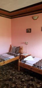 two beds in a room with pink walls at Mechta Guest House in Koprivshtitsa