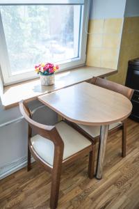 a table and two chairs and a table and a window at Modern 2-room flat in the city center in Šiauliai