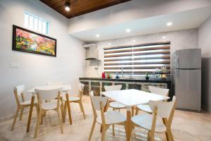 a kitchen and dining room with white tables and chairs at Canning 33 in Ipoh