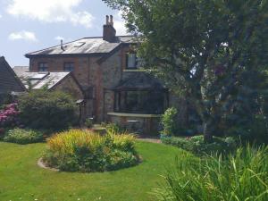 an old brick house with a garden in front of it at Thornham Cottage in Ivybridge