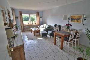 a living room with a table and a couch at Freundliche Ferienwohnung direkt hinter dem Deich in Friedrichskoog