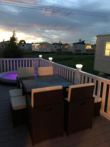 a patio with a table and chairs on a deck at 9 shearwater Tattershall Lakes Country Park in Tattershall
