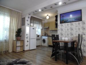 Il comprend une cuisine et une salle à manger avec une table et un réfrigérateur. dans l'établissement Студия в Центре СКАЛА, à Khmelnytsky