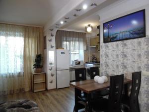 a kitchen with a table and a white refrigerator at Студия в Центре СКАЛА in Khmelnytskyi