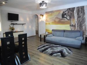 a living room with a blue couch and a tv at Студия в Центре СКАЛА in Khmelnytskyi