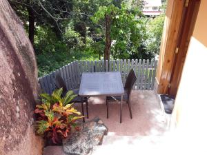 einen Tisch und Stühle auf einer Terrasse mit einem Zaun in der Unterkunft Exotic Guest House in Praslin