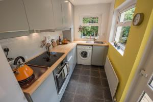 a small kitchen with a sink and a washing machine at Ninety Seven in Holywood