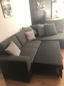 a gray couch with a ottoman in a living room at Cosy Appartment in Rabat