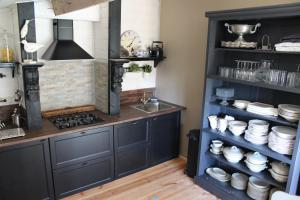 a kitchen with a sink and a shelf with dishes at Dependance in Youx