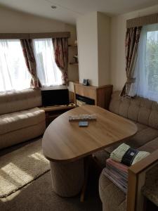 a living room with a table and a couch at Caravan Willerby Gold Star in Looe