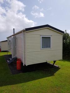 a large white shed sitting in a yard at Caravan Willerby Gold Star in Looe