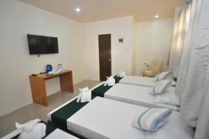 a hotel room with two beds and a television at RNR Suites in Legazpi
