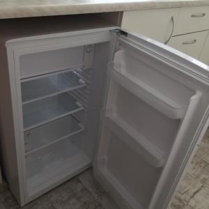 an empty refrigerator with its door open in a kitchen at Cat Garden Deluxe Apartments Riga in Rīga