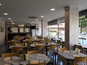 a restaurant with tables and chairs in a room at Hotel Etoile in Rimini