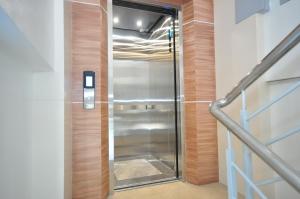 un ascensore con porta a vetri in un edificio di RNR Suites a Legazpi
