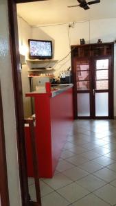 a kitchen with a red counter with a tv on the wall at Hotel St-Antoine in Antananarivo